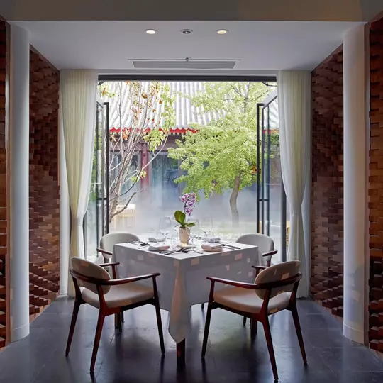 A dining table in front of a floor-to-ceiling window.