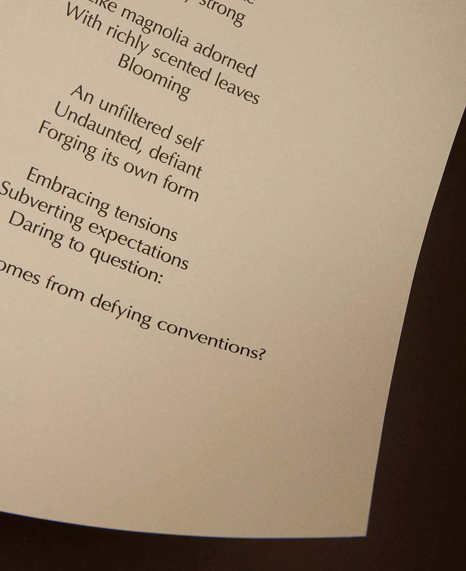 Partial view of a poem printed on cream paper with a curved page edge.